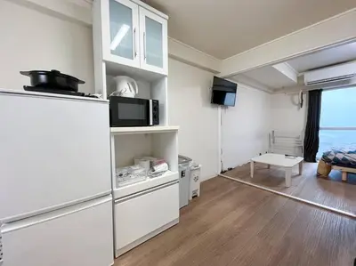 a kitchen with a refrigerator and a living room at Shinjuku 3 min walk from stationp #projector OH33 in Tokyo