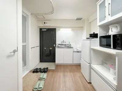 a white kitchen with two pairs of shoes on the floor at Shinjuku 3 min walk from stationp #projector OH33 in Tokyo