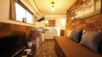 a living room with a couch and a kitchen at Shinjuku 3 min walk from station projector #OH5 in Tokyo