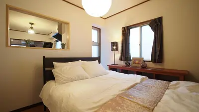 a bedroom with a bed with a mirror on the wall at Shinjuku 3 min walk from station projector #OH5 in Tokyo