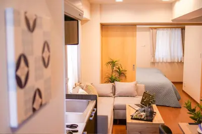a living room with a couch and a bed at Residence Hotel Ryogoku in Tokyo