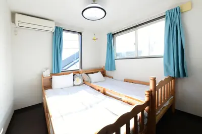 two beds in a room with two windows at JING HOUSE\u4eac\u6210\u9ad8\u7802\u99c55\u5206\u8c6a\u83ef\u4e00\u6238\u5efa\u3066\u6700\u59278\u4eba\u6210\u7530\u7fbd\u7530\u76f4\u901a\u7121\u6599\u99d0\u8eca\u6d45\u8349\u30b9\u30ab\u30a4\u30c4\u30ea\u30fc\u8fd1\u304ftokyo narita in Tokyo