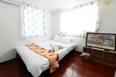 a bedroom with a bed with a teddy bear laying on it at JING HOUSE\u4eac\u6210\u9ad8\u7802\u99c55\u5206\u8c6a\u83ef\u4e00\u6238\u5efa\u3066\u6700\u59278\u4eba\u6210\u7530\u7fbd\u7530\u76f4\u901a\u7121\u6599\u99d0\u8eca\u6d45\u8349\u30b9\u30ab\u30a4\u30c4\u30ea\u30fc\u8fd1\u304ftokyo narita in Tokyo