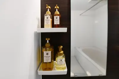 a shelf with four bottles of oils in a bathroom at JING HOUSE\u4eac\u6210\u9ad8\u7802\u99c55\u5206\u8c6a\u83ef\u4e00\u6238\u5efa\u3066\u6700\u59278\u4eba\u6210\u7530\u7fbd\u7530\u76f4\u901a\u7121\u6599\u99d0\u8eca\u6d45\u8349\u30b9\u30ab\u30a4\u30c4\u30ea\u30fc\u8fd1\u304ftokyo narita in Tokyo