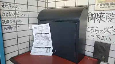 a box with a sign next to a wall with graffiti at \u30ef\u30f3\u30d5\u30ed\u30a2\u8cb8\u5207 in Tokyo