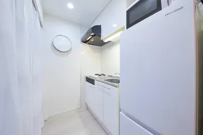 a small kitchen with white cabinets and a sink at Shinjuku Kabukicho Designer's Apartment IV in Tokyo