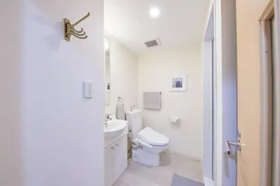 a white bathroom with a toilet and a sink at Shinjuku Kabukicho Designer's Apartment IV in Tokyo