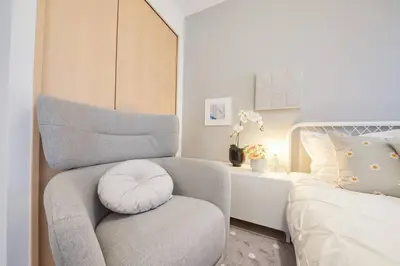 a bedroom with a chair next to a bed at Shinjuku Kabukicho Designer's Apartment V in Tokyo