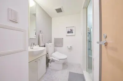 a white bathroom with a toilet and a sink at Shinjuku Kabukicho Designer's Apartment V in Tokyo