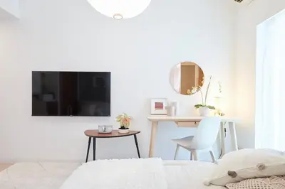 a bedroom with a bed and a table and a mirror at Shinjuku Kabukicho Designer's Apartment VI in Tokyo