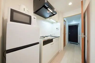 a white kitchen with a sink and a microwave at Shinjuku Kabukicho Designer's Apartment VI in Tokyo