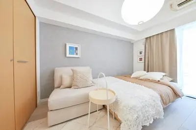 a bedroom with a bed and a white chair at Shinjuku Kabukicho Designer's Apartment VII in Tokyo
