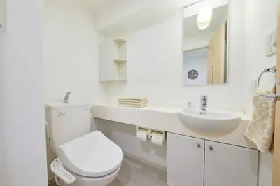 a white bathroom with a toilet and a sink at Shinjuku Kabukicho Designer's Apartment VII in Tokyo