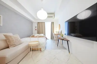 a bedroom with a bed and a couch and a tv at Shinjuku Kabukicho Designer's Apartment VII in Tokyo