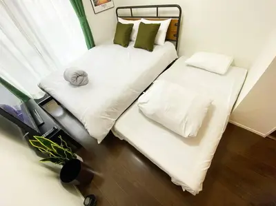two beds in a room with white sheets and pillows at Very near Skytree Asakusa Newly build apartment 102 in Tokyo