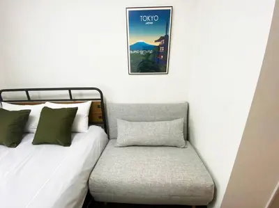 a bed and a chair with a picture on the wall at Very near Skytree Asakusa Newly build apartment 102 in Tokyo