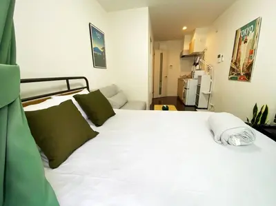 a white bed with green pillows in a room at Very near Skytree Asakusa Newly build apartment 102 in Tokyo