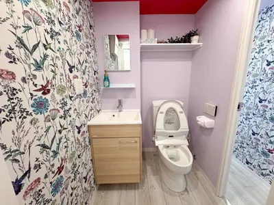 a bathroom with a toilet and a floral shower curtain at Skyfeel Okubo A in Tokyo