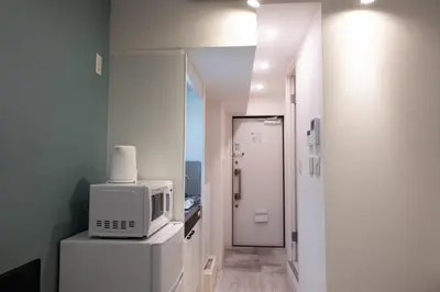 a room with a microwave on top of a refrigerator at Skyfeel Okubo A in Tokyo