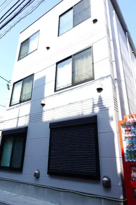 a white building with a garage at Skyfeel Okubo A in Tokyo