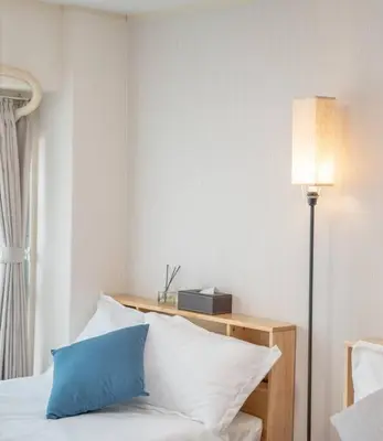 a bedroom with a bed with a blue pillow and a lamp at 12 MIN walk to Shinjuku STR ,6 MIN Higashishinjuku ,nearest kabukicho ,shinjuku oen, in Tokyo