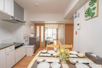 a kitchen with a table with white dishes on it at 12 MIN walk to Shinjuku STR ,6 MIN Higashishinjuku ,nearest kabukicho ,shinjuku oen, in Tokyo