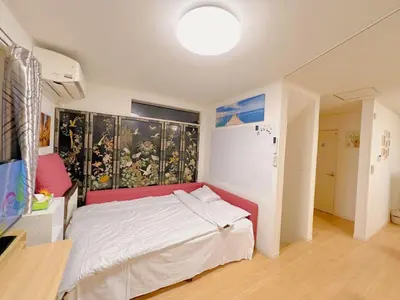 a bedroom with a bed and a large painting on the wall at JINGHOUSE Takasago detached house - Vacation STAY 17050 in Tokyo