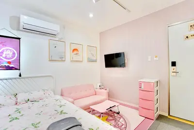 a bedroom with a pink bed and a tv at \u8c4a\u5cf6\u6c11\u5bbf206 in Tokyo
