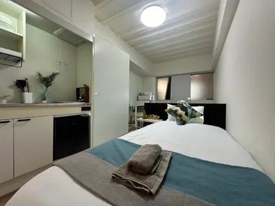 a bedroom with a bed with a towel on it at nestay inn tokyo waseda in Tokyo