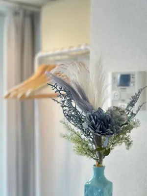 a vase with feathers and flowers in a room at nestay inn tokyo waseda in Tokyo