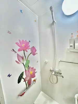 a bathroom with a shower with pink flowers on the wall at \u4e0a\u91ce\u516c\u56ed\u65e5\u5f0f\u6c11\u5bbf in Tokyo