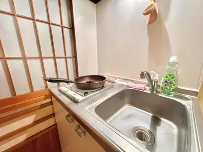 a kitchen sink with a pan on a stove at \u4e0a\u91ce\u516c\u56ed\u65e5\u5f0f\u6c11\u5bbf in Tokyo
