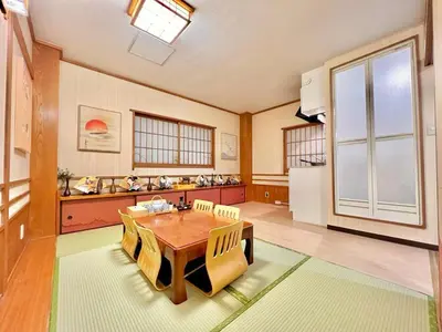 a large room with a table and a refrigerator at \u4e0a\u91ce\u516c\u56ed\u65e5\u5f0f\u6c11\u5bbf in Tokyo
