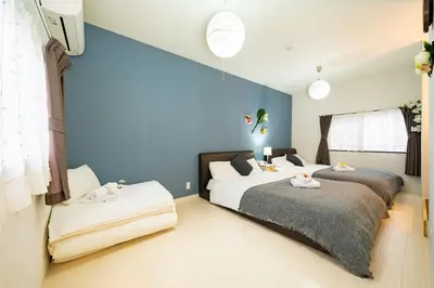 two beds in a bedroom with blue walls at 5, Kikukawa, Entire house for rent, \u83ca\u5ddd in Tokyo