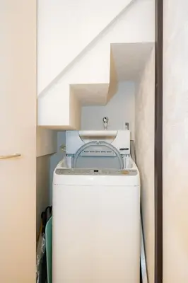 a washer and dryer in a laundry room with a staircase at 5, Kikukawa, Entire house for rent, \u83ca\u5ddd in Tokyo