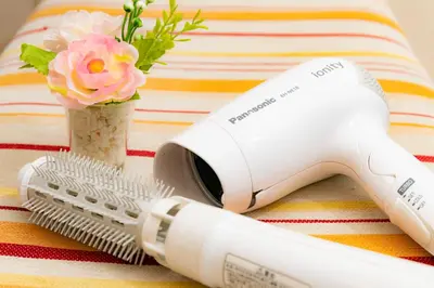a white hair dryer and a hairbrush next to a flower at 5, Kikukawa, Entire house for rent, \u83ca\u5ddd in Tokyo