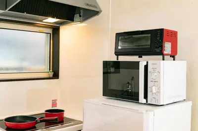 a microwave on top of a refrigerator in a kitchen at 5, Kikukawa, Entire house for rent, \u83ca\u5ddd in Tokyo