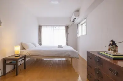 a bedroom with a bed and a dresser and a window at Komorebi in Tokyo