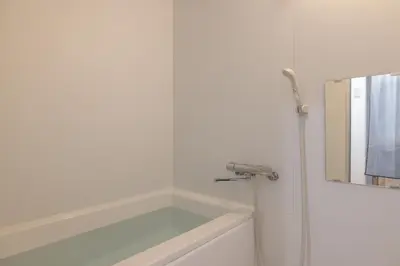 a white bathroom with a tub and a mirror at Komorebi in Tokyo