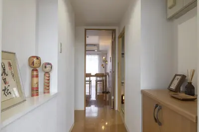 a hallway with white walls and a room with a table at Komorebi in Tokyo