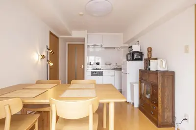 a kitchen and dining room with a wooden table and chairs at Komorebi in Tokyo