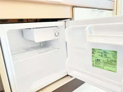 an empty refrigerator with its door open in a kitchen at Ikebukuro Sugamo 203 in Tokyo