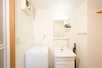 a white bathroom with a sink and a mirror at Mi-APT MIDORI in Tokyo