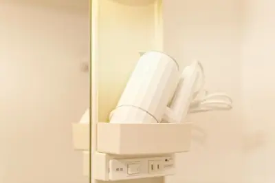 a white hairdryer in a holder on a wall at Mi-APT MIDORI in Tokyo