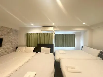 a room with three beds and a window at \u30a2\u30f3\u30c9\u30b9\u30c6\u30a4\u3059\u3082\u3046\u30db\u30c6\u30eb402 in Tokyo