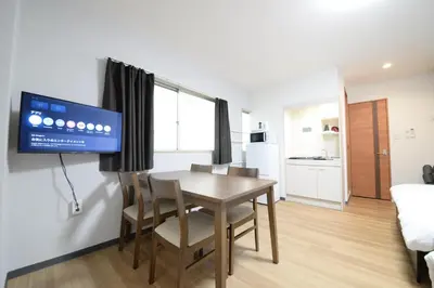 a dining room with a table and chairs and a tv at \u548c\u306e\u6953cottage\u7b2c\u4e8c202 \u65b0\u5bbf\u6b4c\u821e\u4f0e\u753a\u8fd1\u96a3 in Tokyo