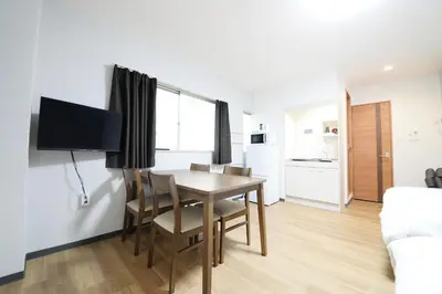 a living room with a dining room table and a kitchen at \u548c\u306e\u6953cottage\u7b2c\u4e8c202 \u65b0\u5bbf\u6b4c\u821e\u4f0e\u753a\u8fd1\u96a3 in Tokyo