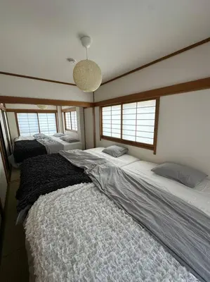 a bedroom with two beds and two windows at Style Lab\u304a\u82b1\u8336\u5c4b2 in Tokyo