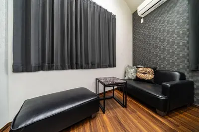 a room with a black leather couch and a table at 88, Kanegafuchi 3A, Entire house for rent, \u9418\u30f6\u6df53A in Tokyo