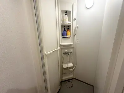 a small bathroom with a toilet with bottles on it at \u30a2\u30f3\u30c9\u30b9\u30c6\u30a4\u3059\u3082\u3046\u30db\u30c6\u30eb403 in Tokyo